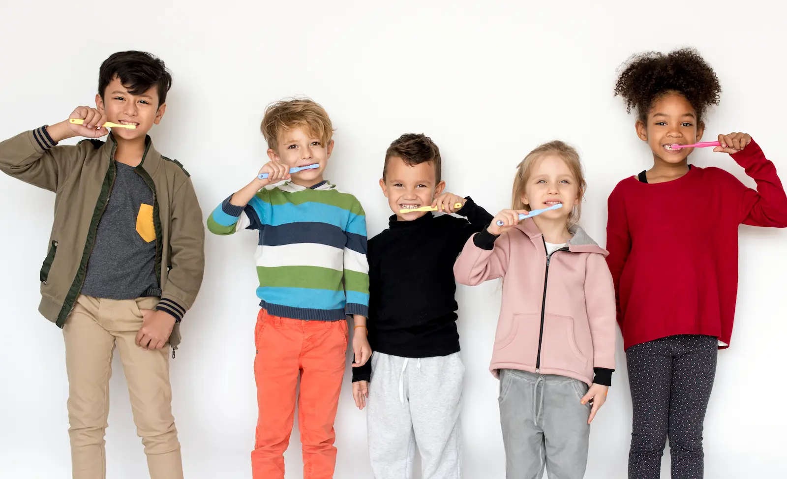 cinco niños lavandose los dientes